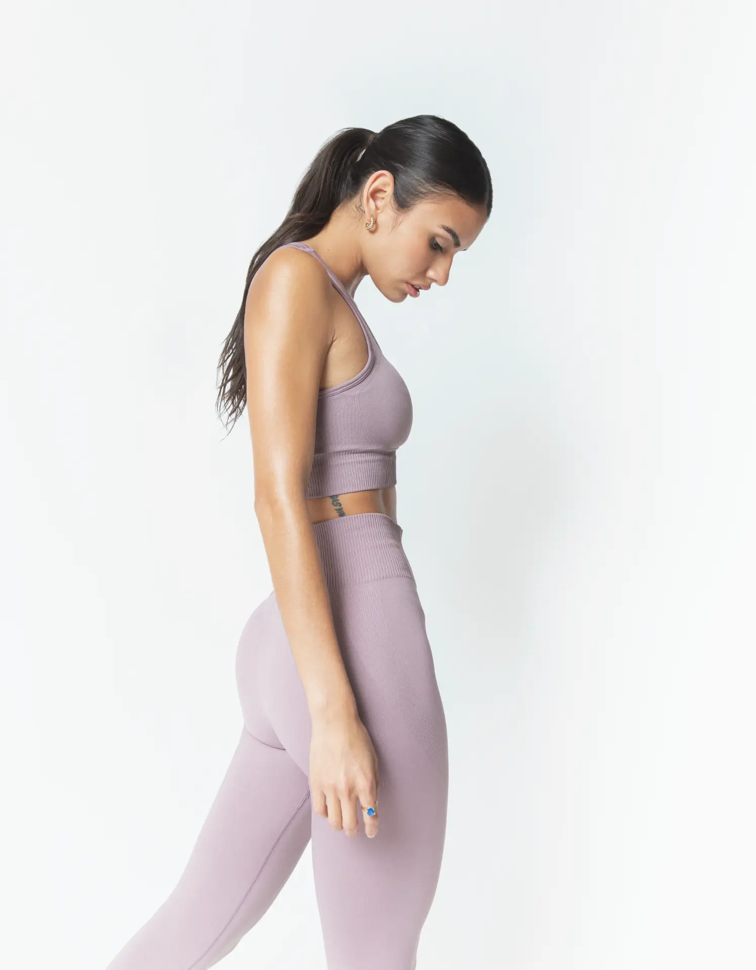 Profile studio image of a model in a mauve two-piece set