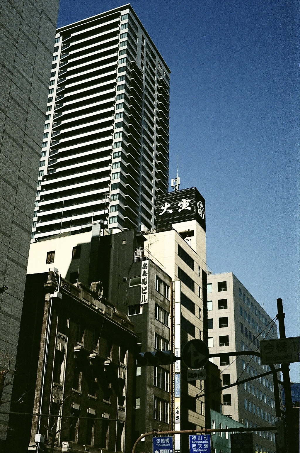 Looking up at a high-rise tower against a deep blue sky