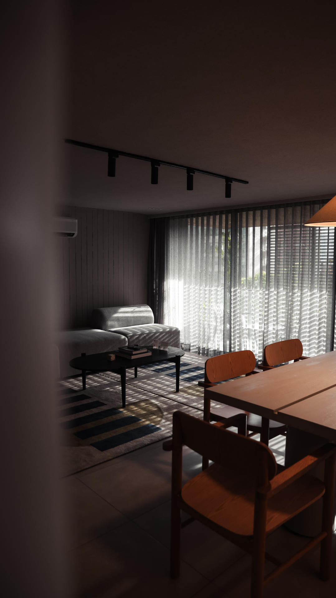 Dining and living room interior striped with light from window blinds