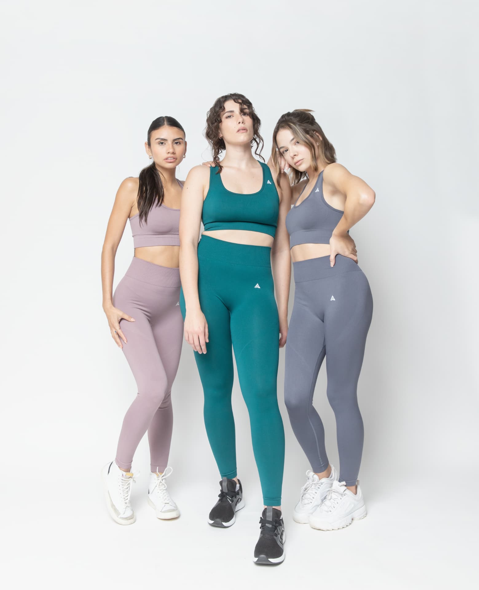 Three models together in mauve, teal and slate sets on white