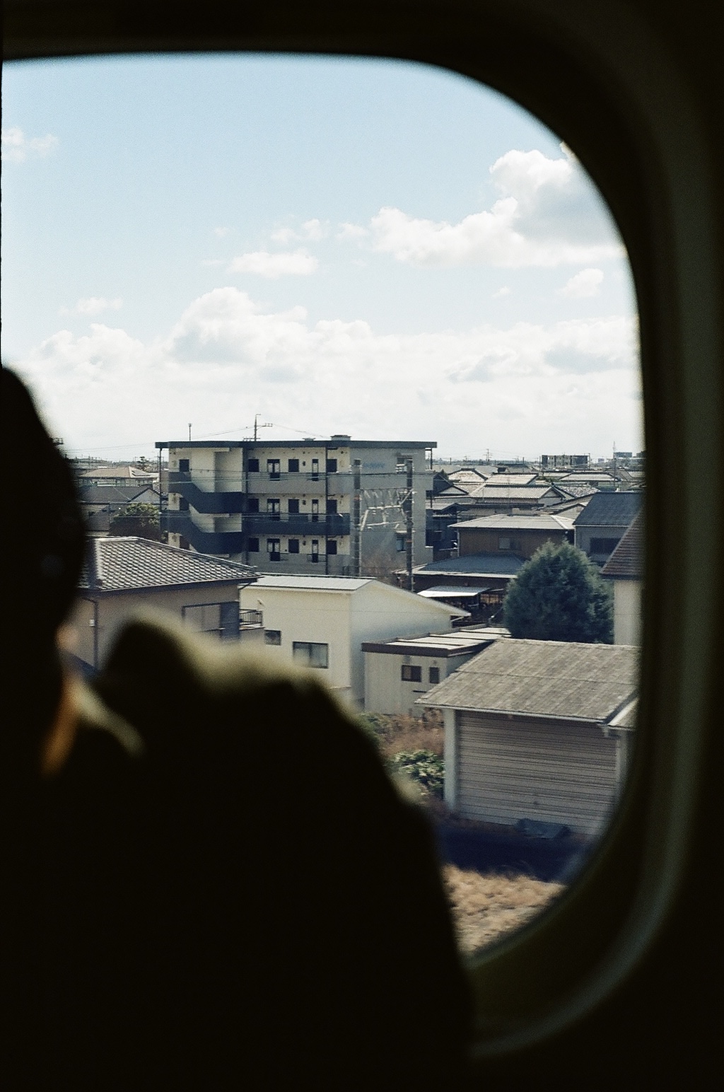 Rooftops and houses seen through a train window