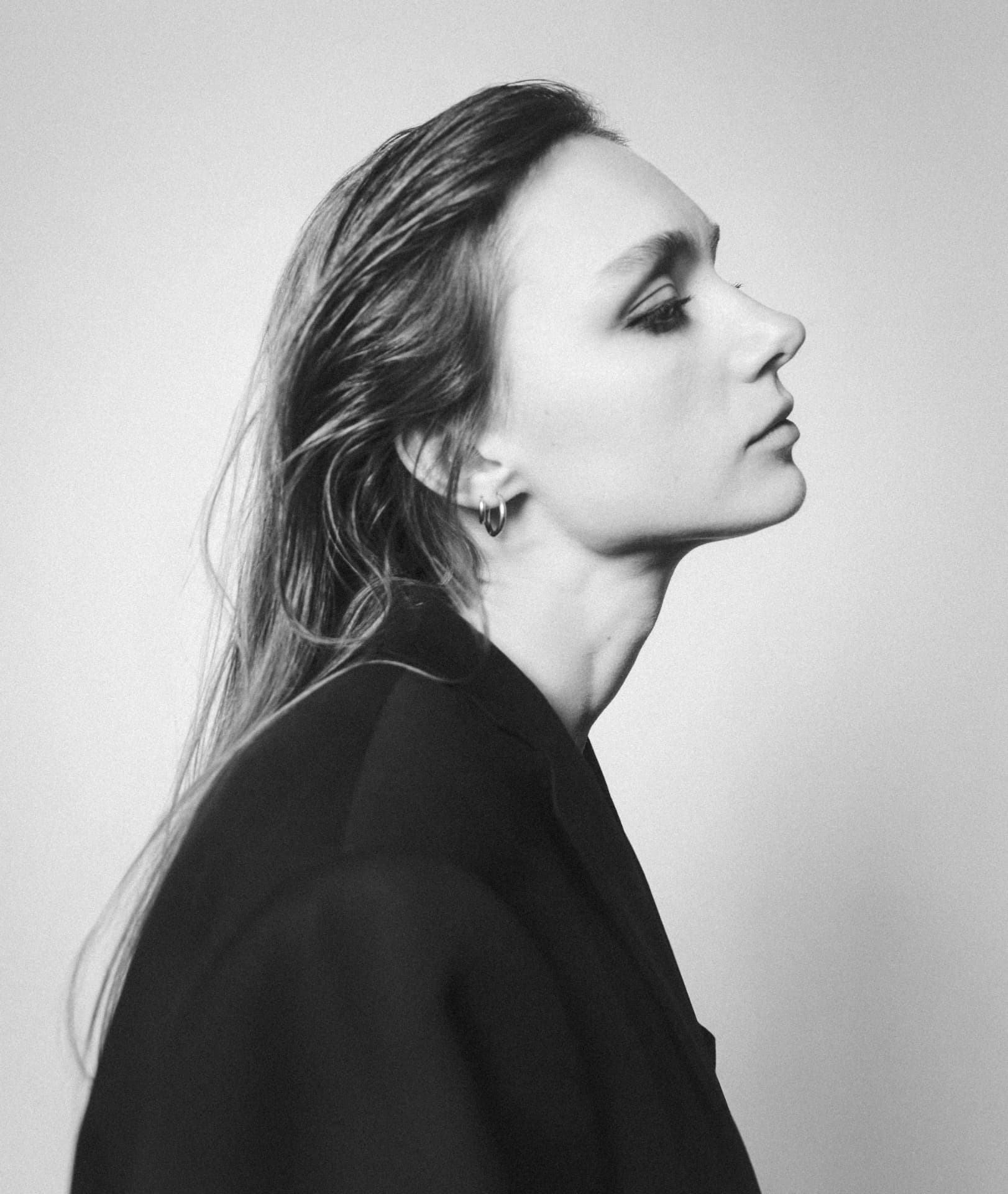 Black and white studio profile portrait in a black blazer